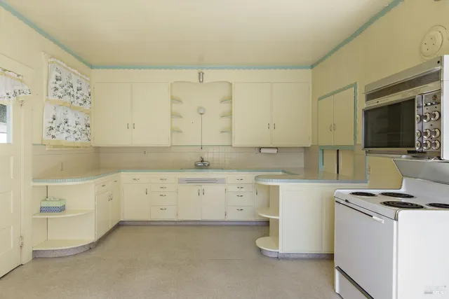 a kitchen with cabinets appliances and a window