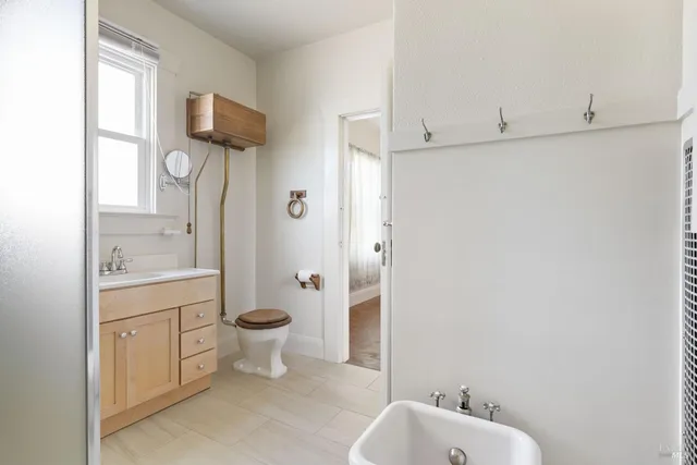 a bathroom with a toilet a sink and a window