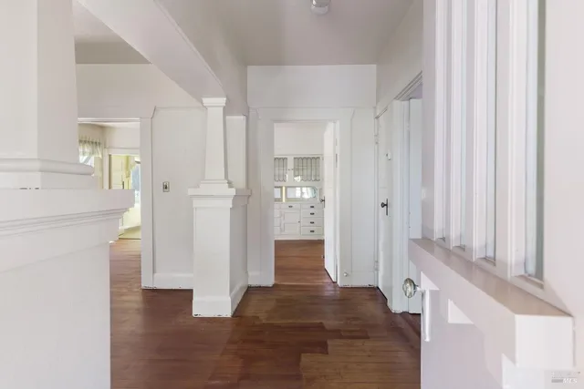 a view of a hallway with wooden floor and staircase