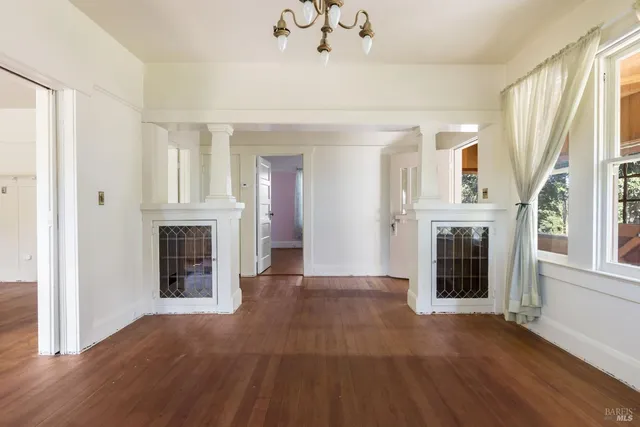wooden floor fireplace and windows in an empty room