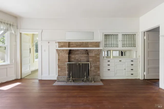 an empty room with wooden floor and cabinet