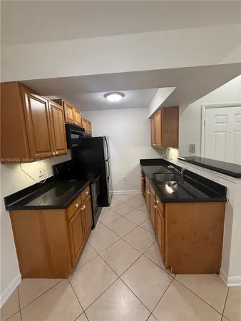 a kitchen with stainless steel appliances granite countertop a refrigerator a stove a sink and a microwave