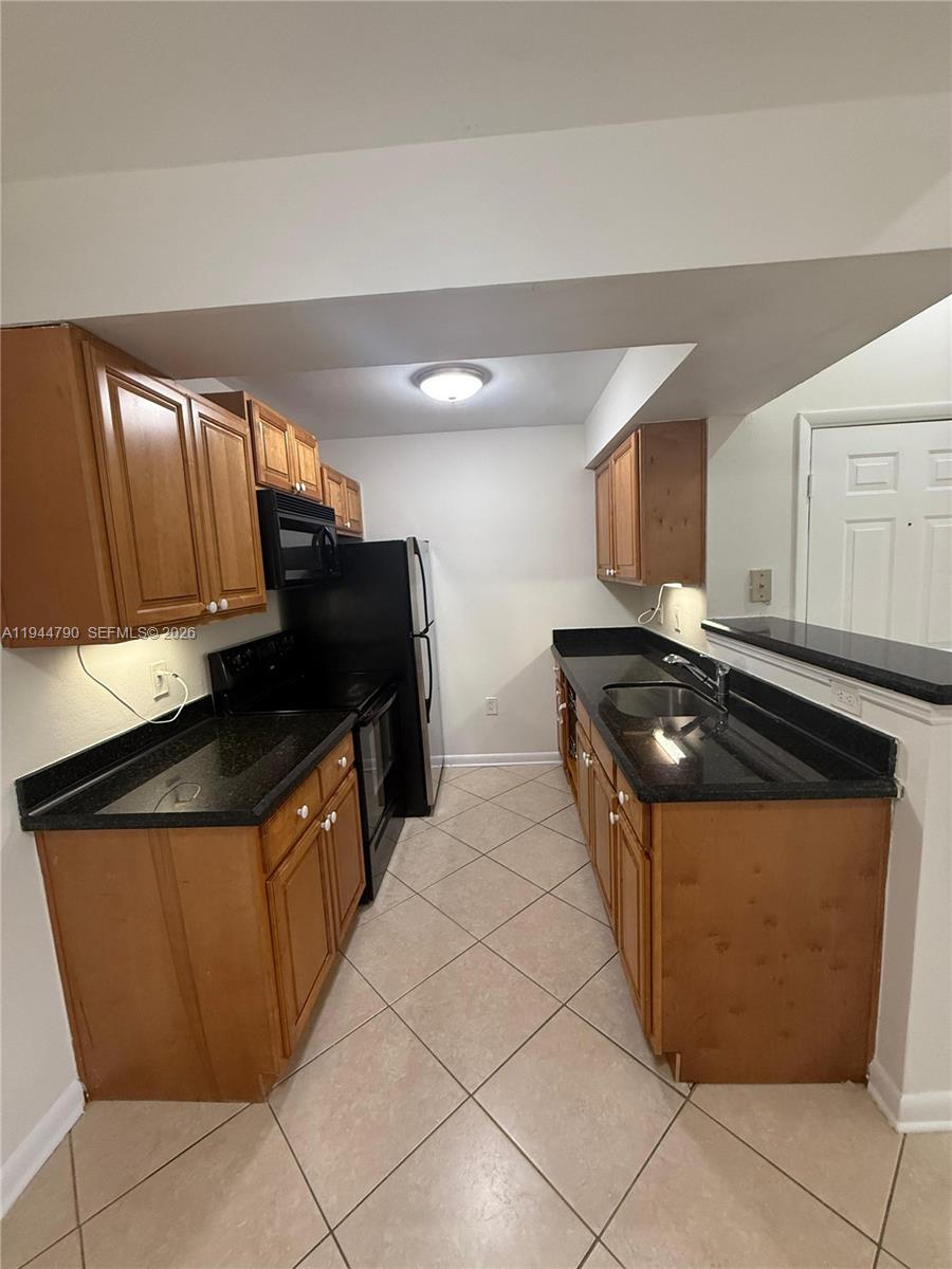 15581 Southwest 104th Terrace, Unit 222 Miami, FL 33196 - Photo 11 of 23 a kitchen with stainless steel appliances granite countertop a sink and a stove