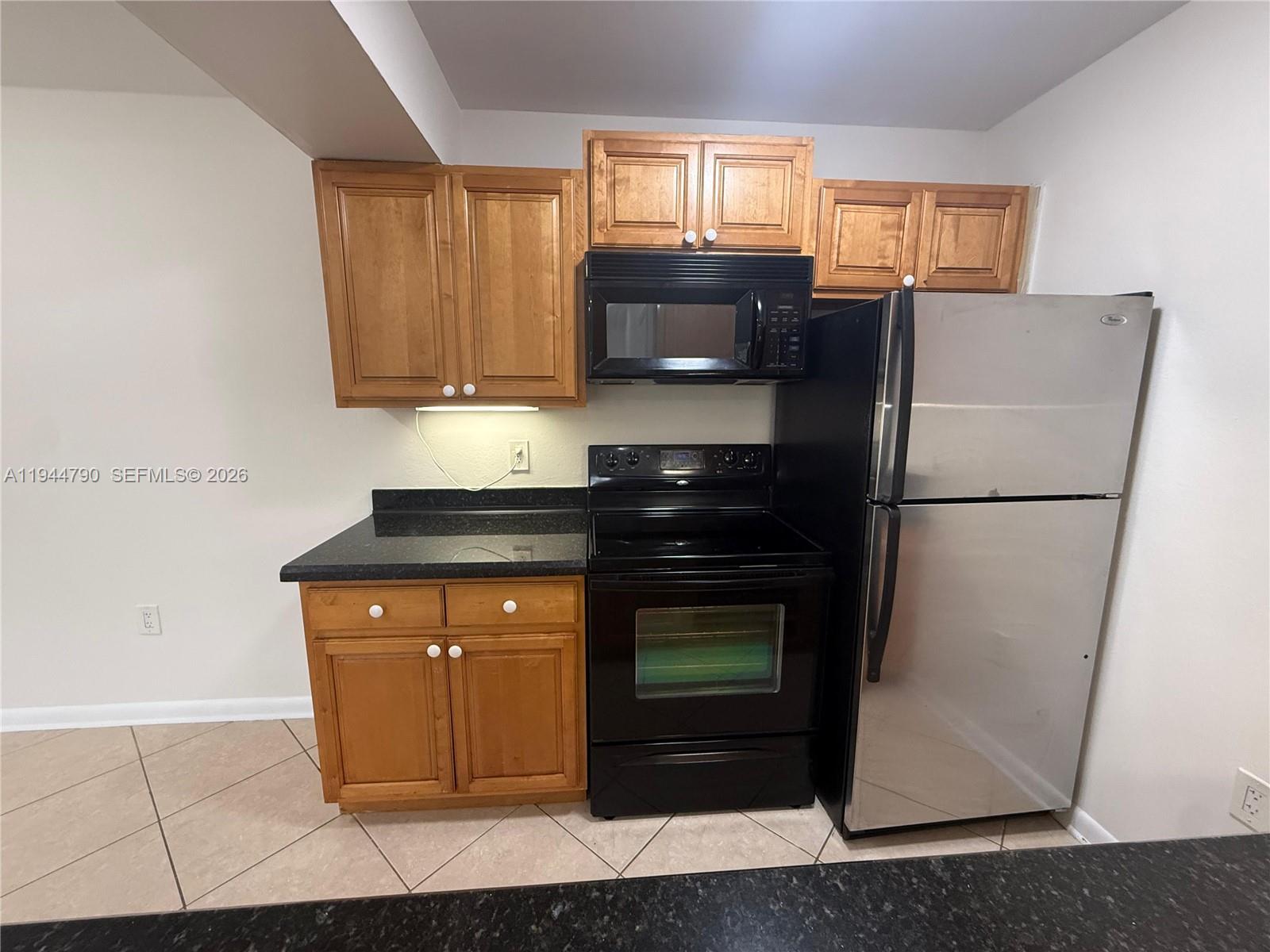 15581 Southwest 104th Terrace, Unit 222 Miami, FL 33196 - Photo 12 of 23 a kitchen with stainless steel appliances granite countertop a refrigerator a stove a sink and a microwave