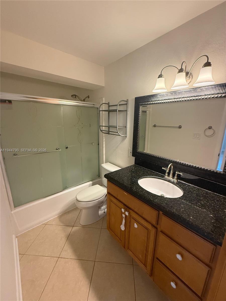 15581 Southwest 104th Terrace, Unit 222 Miami, FL 33196 - Photo 13 of 23 a bathroom with a granite countertop sink toilet and shower