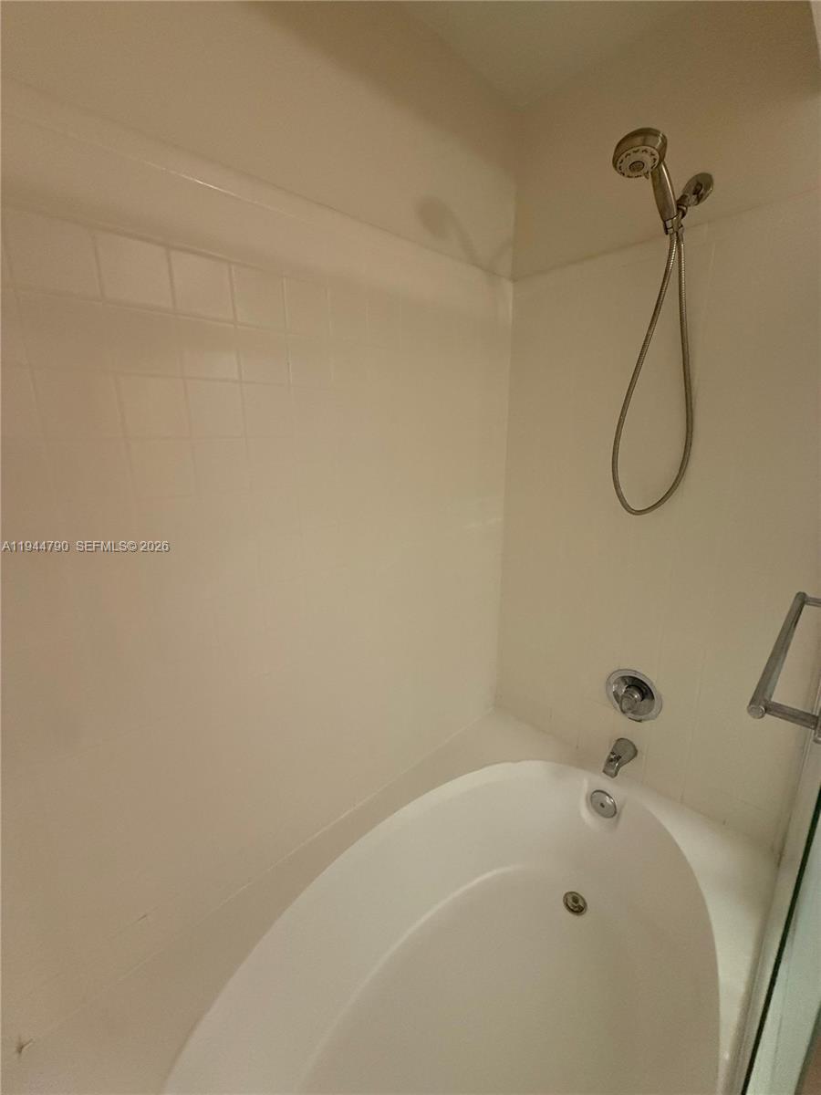 15581 Southwest 104th Terrace, Unit 222 Miami, FL 33196 - Photo 16 of 23 a white bath tub sitting next to a white sink and a shower