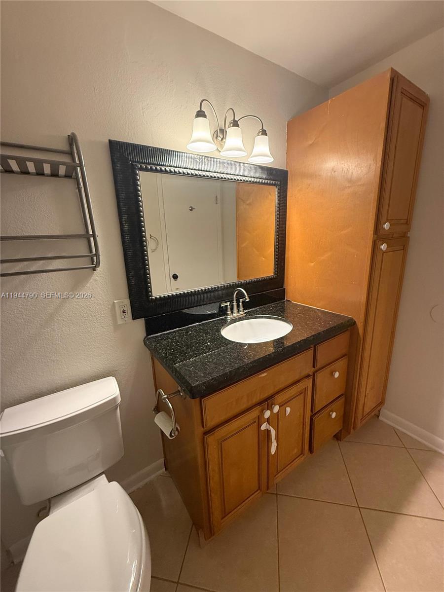 15581 Southwest 104th Terrace, Unit 222 Miami, FL 33196 - Photo 17 of 23 a bathroom with a sink a toilet and mirror
