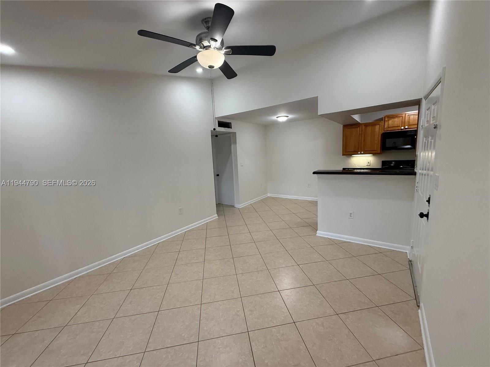 15581 Southwest 104th Terrace, Unit 222 Miami, FL 33196 - Photo 5 of 23 an empty room with projector and fan
