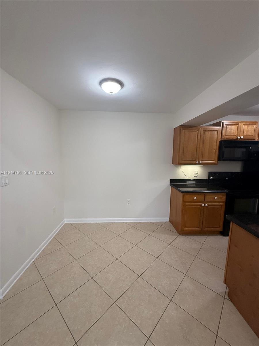 15581 Southwest 104th Terrace, Unit 222 Miami, FL 33196 - Photo 8 of 23 a kitchen with granite countertop white cabinets and stainless steel appliances
