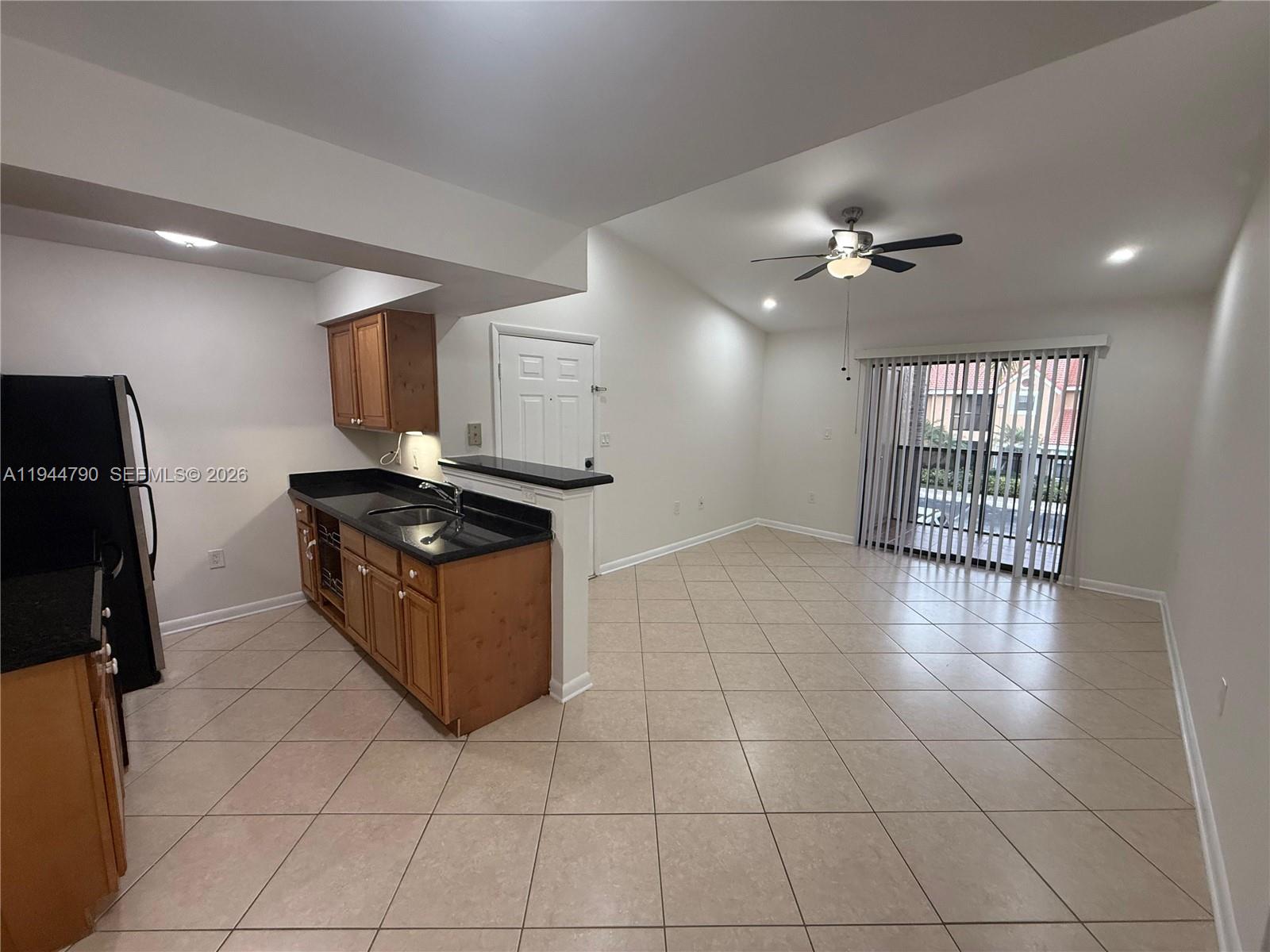 15581 Southwest 104th Terrace, Unit 222 Miami, FL 33196 - Photo 9 of 23 a kitchen with granite countertop a stove a sink and a refrigerator