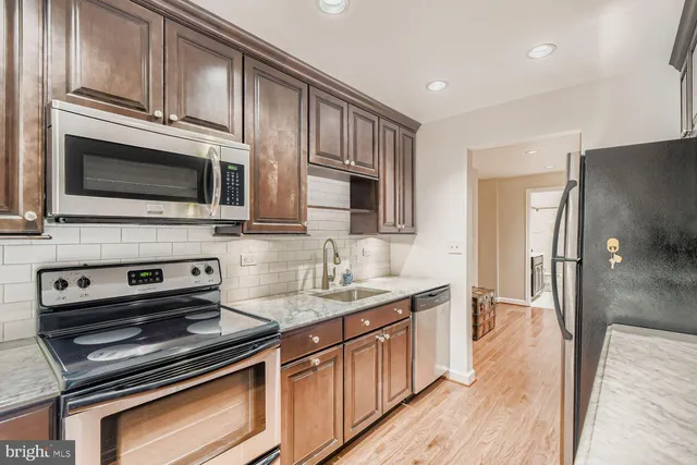 a kitchen with stainless steel appliances a stove microwave and sink