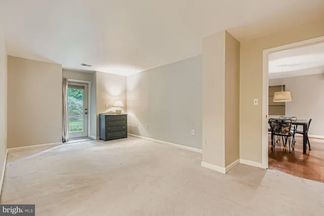 a view of an empty room with furniture and a window