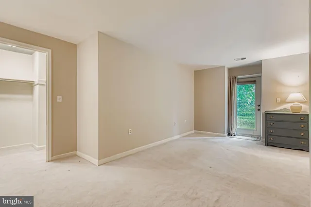 an empty room with windows and cabinet