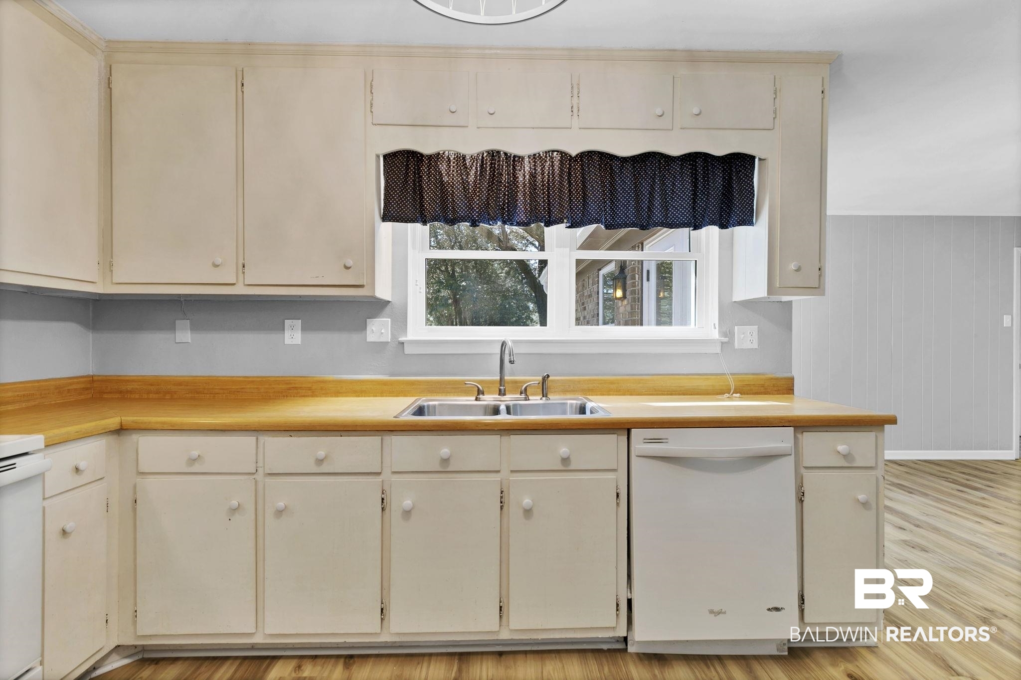 5817 Woodgate Road Mobile, AL 36609 - Photo 22 of 85 Kitchen with white dishwasher, light countertops, cream cabinetry, light wood-style floors, and a sink