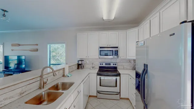 a kitchen with white cabinets and stainless steel appliances