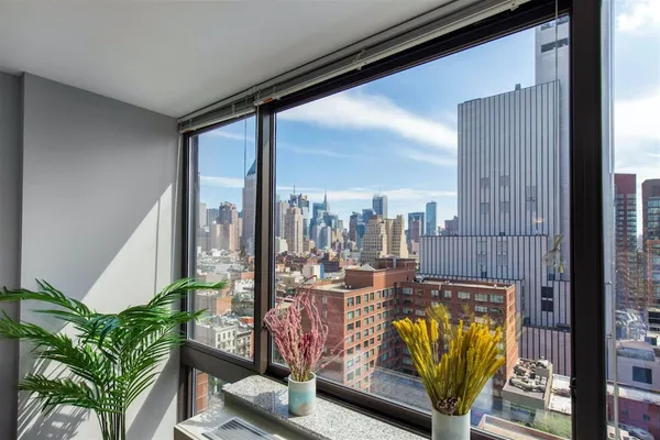 a view of a living room with furniture and floor to ceiling window