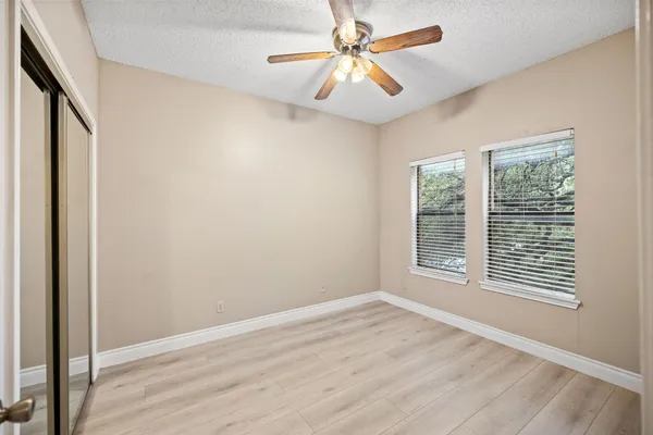 an empty room with closet and windows