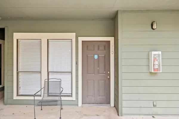 a view of an empty room with wooden floor fireplace and a window