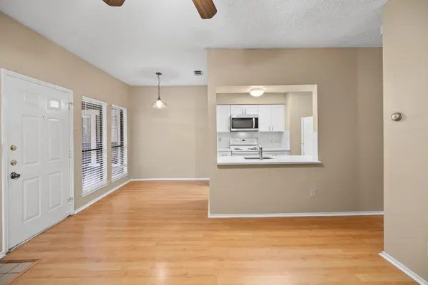 a view of a kitchen with a fireplace a ceiling fan and wooden floor
