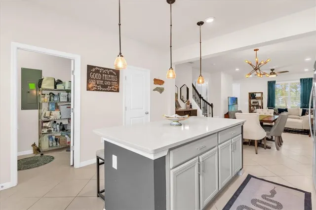 a kitchen with a sink a counter and chairs in it