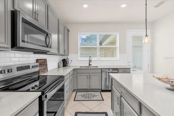 a kitchen with a stove a sink and a microwave