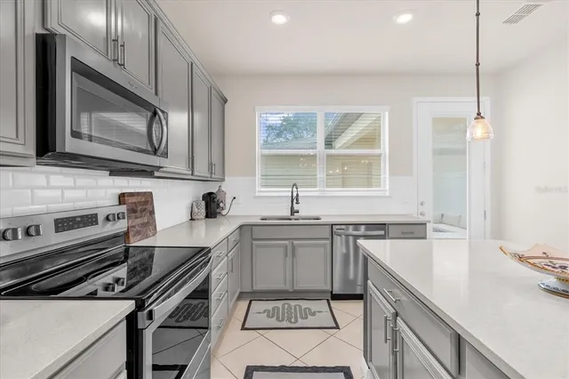 a kitchen with a stove a sink and a microwave
