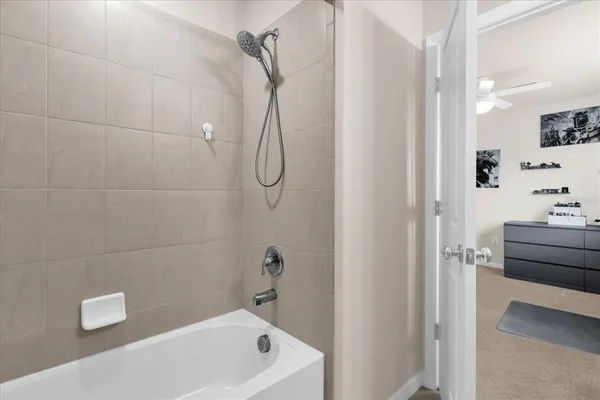 a bathroom with a tub a sink a window and a shower