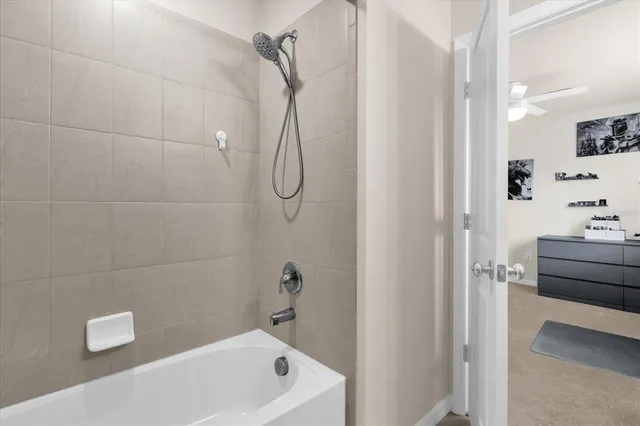 a bathroom with a tub a sink a window and a shower