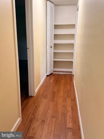 a view of walk in closet with wooden floor