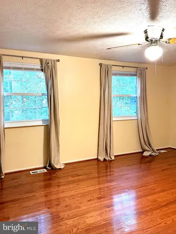 a view of a room with wooden floor and a window