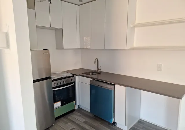 a kitchen with a refrigerator and a stove top oven
