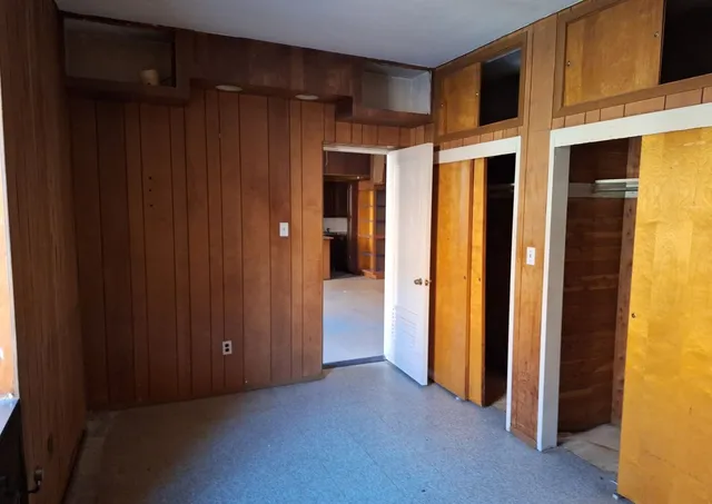 a view of an empty room with a fireplace and a window