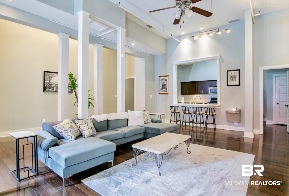 204 Conti Street, Unit 1C Mobile, AL 36602 - Photo 9 of 12 Living area with a high ceiling, dark wood-style flooring, and a ceiling fan