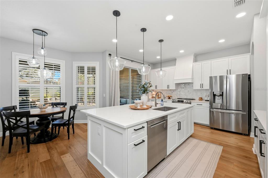 13912 Darchance Road Windermere, FL 34786 - Photo 17 of 49 a kitchen with stainless steel appliances granite countertop a stove a refrigerator a kitchen island a dining table and chairs