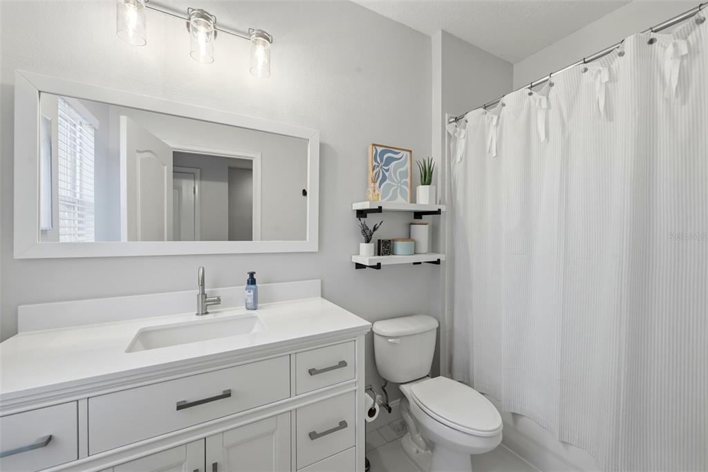 13912 Darchance Road Windermere, FL 34786 - Photo 43 of 49 a bathroom with a sink a mirror a toilet and shower