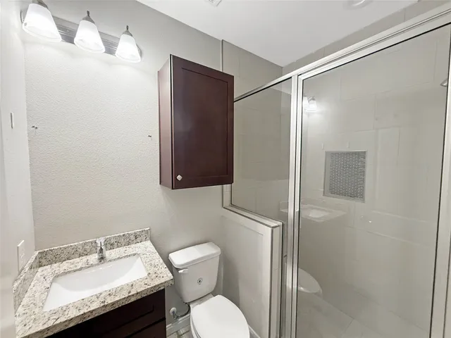 a bathroom with a sink toilet and shower