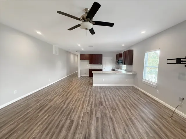a view of a kitchen with a sink and wooden floor