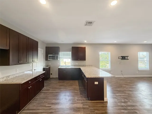 a large kitchen with stainless steel appliances granite countertop a sink counter space and a window