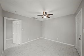 2002 Mustang Road, Unit 2 Alvin, TX 77511 - Photo 6 of 8 an empty room with a ceiling fan and a window