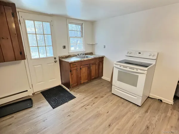 a kitchen with wooden floors and white appliances