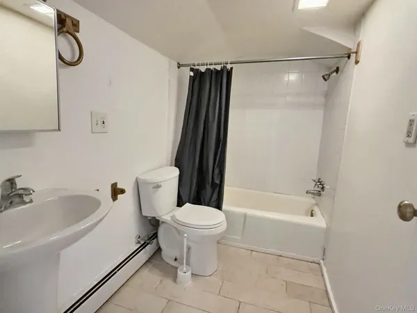 a bathroom with a shower a toilet and a tub