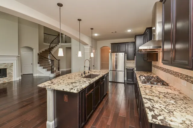 a kitchen with kitchen island granite countertop lots of counter top space and stainless steel appliances