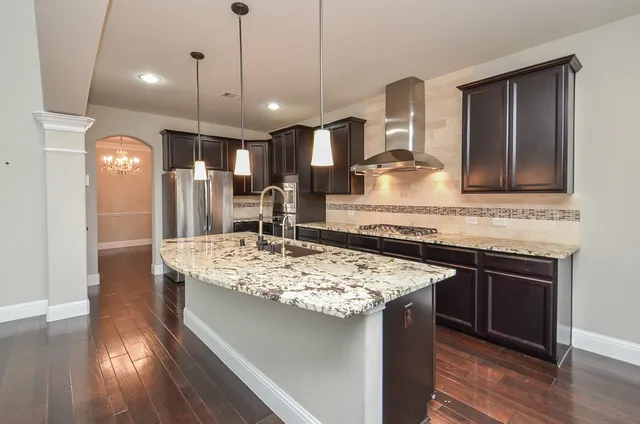 a kitchen with stainless steel appliances granite countertop wooden floors and sink