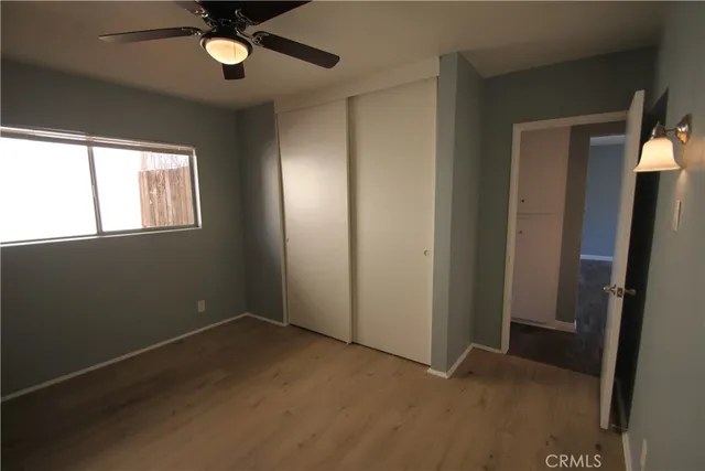 an empty room with a ceiling fan and a window