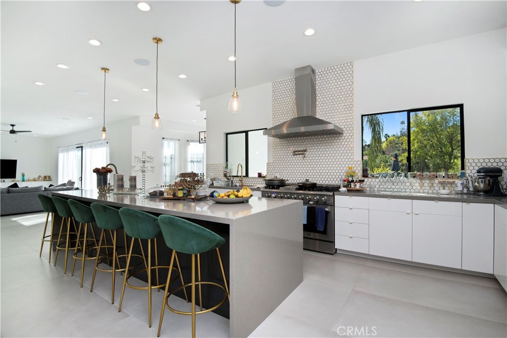 22254 Dumetz Road Woodland Hills, CA 91364 - Photo 11 of 42 a kitchen with stainless steel appliances granite countertop a stove a sink a kitchen island and chairs