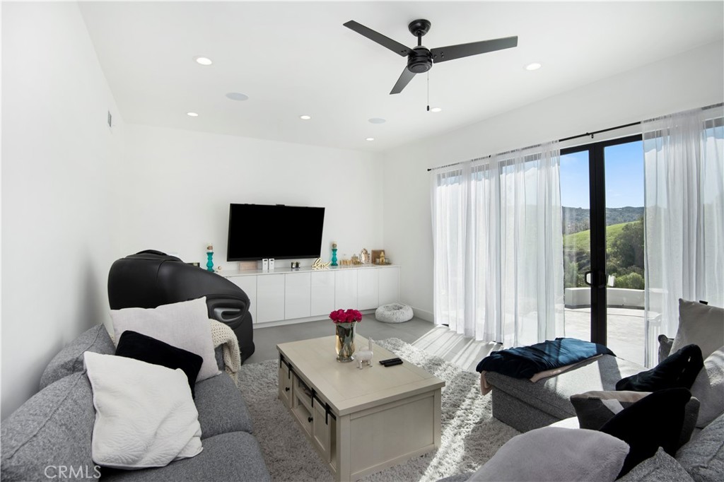 22254 Dumetz Road Woodland Hills, CA 91364 - Photo 14 of 42 a living room with furniture and a flat screen tv