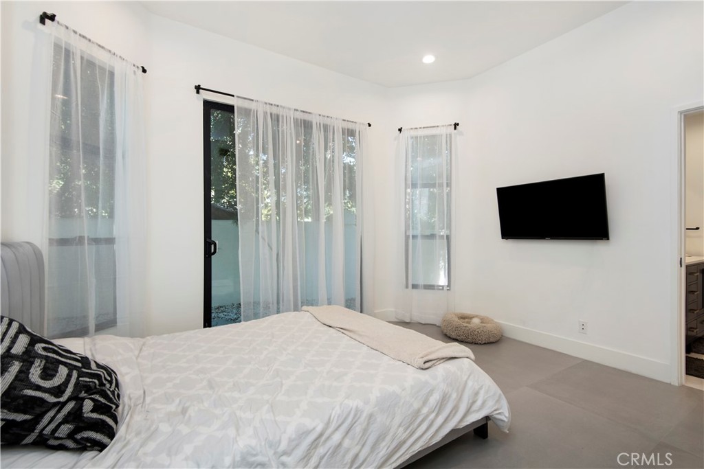 22254 Dumetz Road Woodland Hills, CA 91364 - Photo 20 of 42 a bedroom with a bed mirror tv and a window