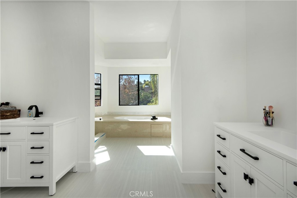 22254 Dumetz Road Woodland Hills, CA 91364 - Photo 30 of 42 a bathroom with a tub sink and mirror