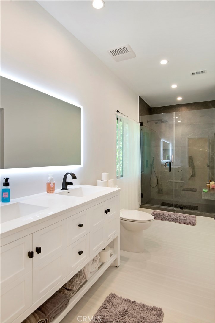 22254 Dumetz Road Woodland Hills, CA 91364 - Photo 35 of 42 a bathroom with a double vanity sink mirror and bathtub