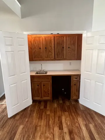 a kitchen with a wooden floor and a sink